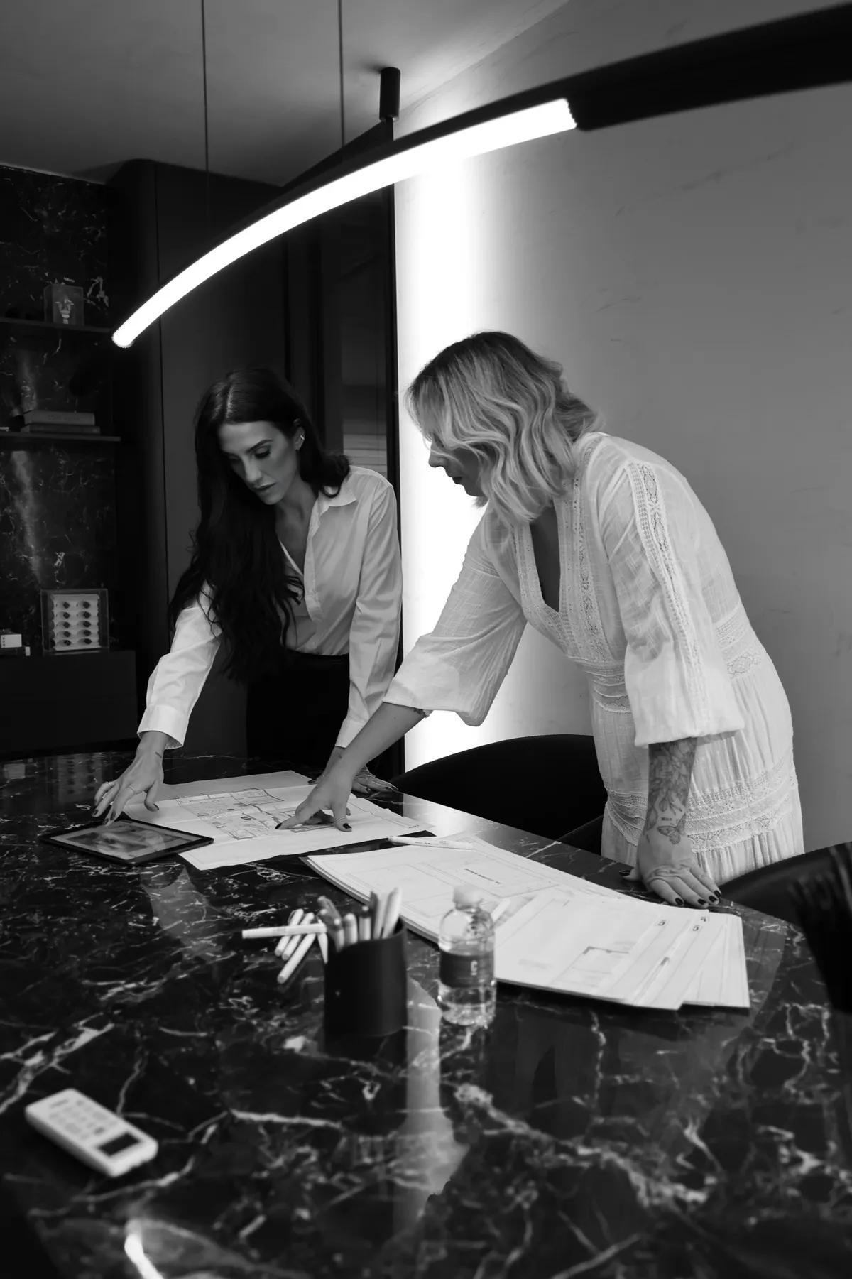 Marcela Castellões e Gabriela Cambraia analisando desenhos de um projeto